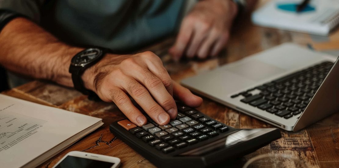 Person using a calculator for tax planning and tax filing